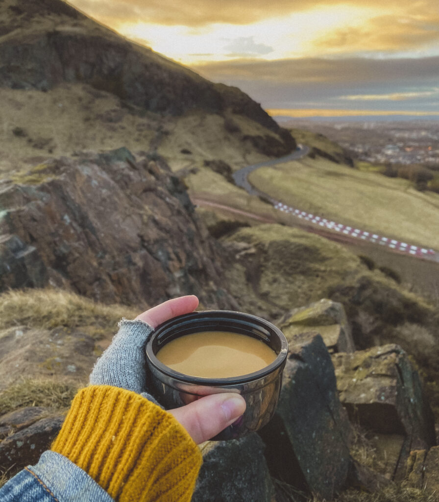cup of tea at sunrise on top of arthurs seat in edinburgh