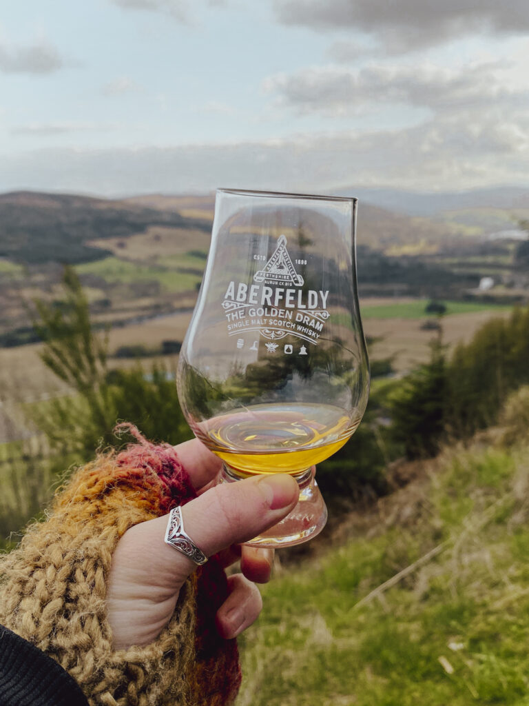 whisky glencairn glass with scottish hills in the background