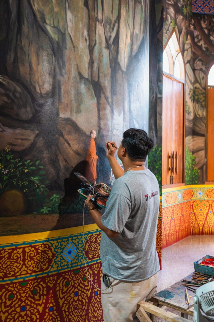 man painting mural tiger cave